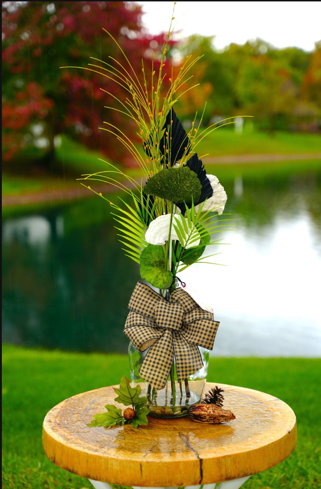 Tall fungi arrangement with checker bow. Glass vase with resin water.